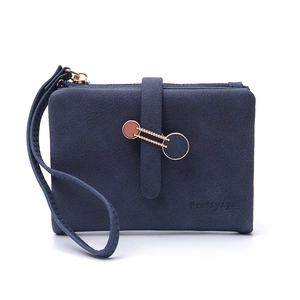 Detail of navy blue matte leather wallet with metallic ring buckle and wristlet strap
