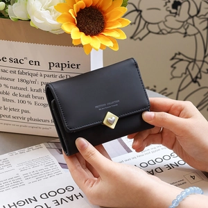 Détail du mini portefeuille en similicuir noir avec fermoir cœur en métal et rabat