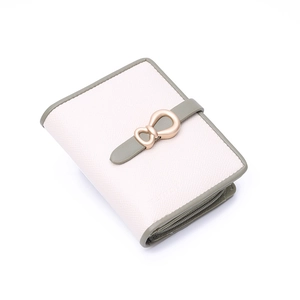 Detailed side view of cream white wallet with green buckle and gold bow ornament