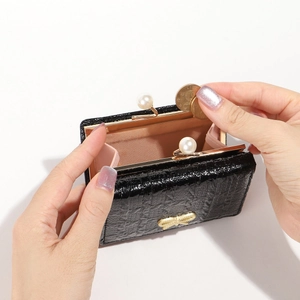 Black crocodile pattern mini wallet featuring elegant pearl clasp and gold bow detail