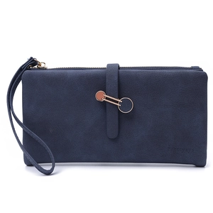 Close-up of deep blue suede wallet with gold ring hardware and wrist strap detail