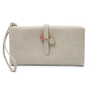 Close-up of beige leather wallet with rose gold chain buckle and wrist strap detail