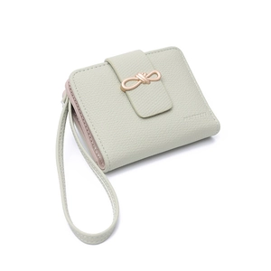 Detail of mint green pebble leather wallet featuring a champagne gold bow buckle and strap