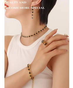 Detail shot of vintage gold jewelry set with black rectangular stones on a female model