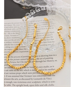 Detail of 18K gold-plated titanium bead bracelet with adjustable lobster clasp and tag