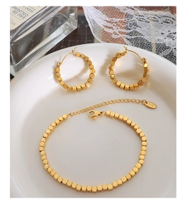 Detail of 18K gold plated jewelry set featuring movable cubes and K18 engraving