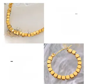 Detail of 18K gold plated titanium steel hoop earrings with movable cube beads