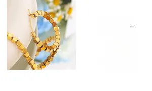 Detailed macro view of 18K gold plated titanium steel cube beaded hoop earrings