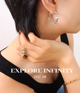 Close-up of 18K gold plated steel jewelry set with movable cubes and natural stones