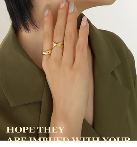 Macro shot of gold-plated thick round ring and cross-wrapped band set on model