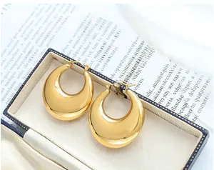 Close-up of chunky gold teardrop hoop earrings in a luxury jewelry display box