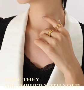 Detail of 18K gold-plated titanium stackable rings with textured and chain patterns