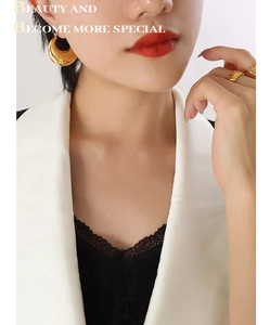 Polished 18K gold plated titanium chunky hoop earrings and textured ring on a model