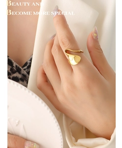 Detail of a fashion irregular golden wavy ring worn by a model in formal attire