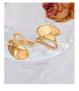 Macro view of gold minimalist fluid wavy rings with highly polished liquid metal finish