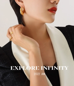 Polished 18K gold-plated chunky hoop earrings and textured rings on a fashion model