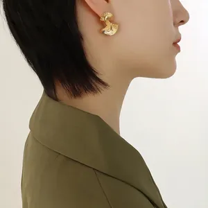 Retro gold stainless steel fan-shaped earrings with hammered texture on female model