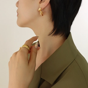 Modern gold irregular lava stud earrings and striped wide band ring set on model