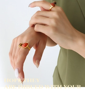 Close-up of gold titanium steel rings with natural tiger eye and red agate on model