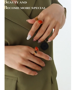 Detail of gold titanium rings with natural red and tiger eye stones on model hands
