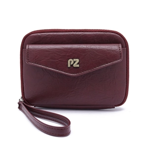 Macro shot of maroon leather passport bag with gold PZ logo and secure zipper closure
