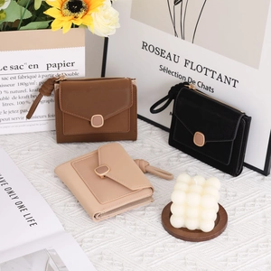 Detailed view of small faux leather women wallets in brown, black, and beige colors