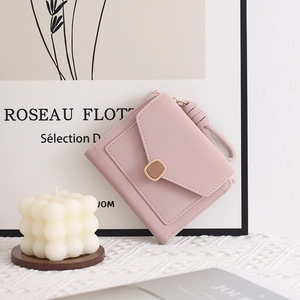 Detailed shot of pink leather wallet featuring a champagne gold buckle and woven strap