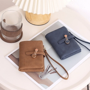 Detail view of brown and navy blue wallets with wrist strap and metal ring buckle