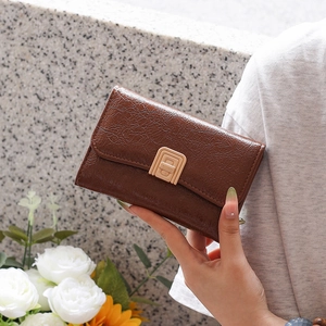 Close-up of brown vintage leather wallet featuring a golden square metallic clasp