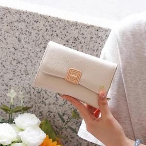 Detailed side view of cream faux leather wallet with gold buckle and pleated texture
