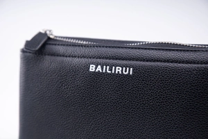 Detailaufnahme der schwarzen PU-Leder-Clutch mit Litchi-Maserung, BAILIRUI-Logo und Zipper