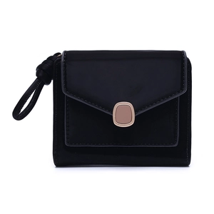 Detail of black envelope wallet featuring rose gold snap and knotted rope wristlet strap
