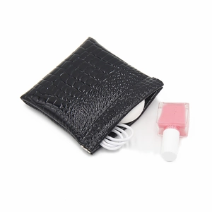 Macro view of black crocodile pattern leather storage pouch with metal closure