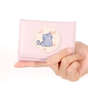 Close-up of a pink tri-fold wallet featuring a cute cartoon cat and heart pattern