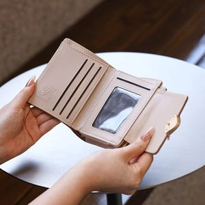 Interior detail of a beige tri-fold wallet showing card slots and ID window