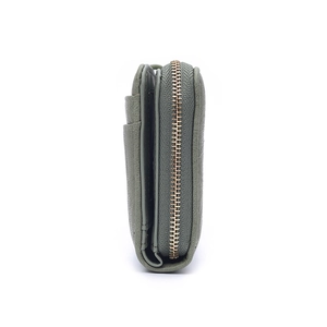 Detail view of multi-layer card slots and golden zipper on green leather wallet