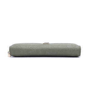 Detail shot of grey-green leather texture and golden metal zipper on long women's wallet