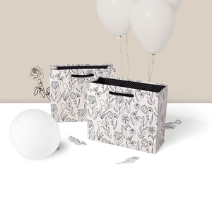 Detailed view of floral line art gift bag with black cord handles and polka dot lining