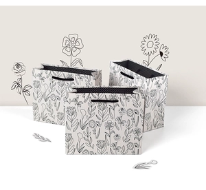 Detail of white gift bags with black floral line art and stylish polka dot interior lining