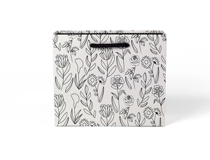 Detail of minimalist floral line art gift bag with black woven handles and white paper texture