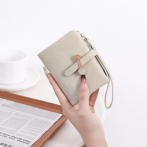 Vue détaillée du portefeuille beige avec anneau métallique et texture en cuir grainé