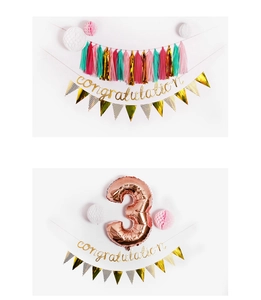Detail view of gold glitter congratulations banner with colorful paper tassels and flags