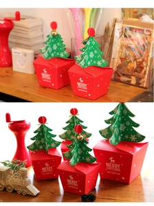 Detail of Christmas gift boxes with 3D tree lid and reindeer motif on a festive table