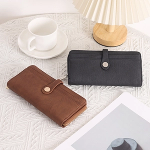 Detail of vintage long wallets in brown and grey with multi-card slots and snap closure