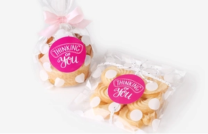 Detail of round magenta stickers with 'Thinking of You' text on gift packaging