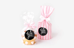 Detailed view of polka dot and striped gift bags with pink bows and I Love You stickers