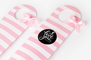 Close-up of pink striped gift tags with silk bows and love you text decoration