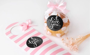 Detail of 'I love you' round gift stickers with pink ribbon and striped hang tags