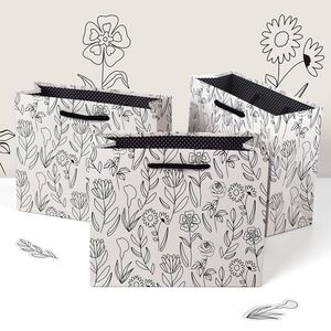 Three-piece set of minimalist white gift bags with black floral line art and polka dot lining
