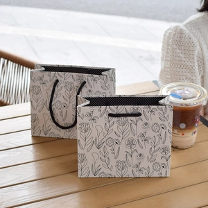 Minimalist grey square floral paper gift bags with black hand-drawn line art patterns